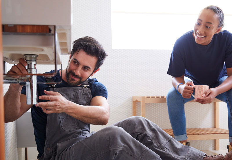 Plumber explaining the issue to a homeowner after plumbing system inspection.
